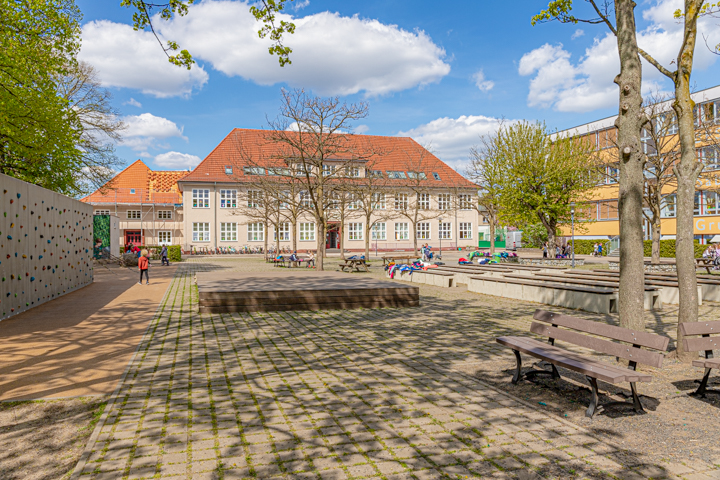 Hofansicht der Grundschule Mahlsdorf mit Kletterwand und Bühne.