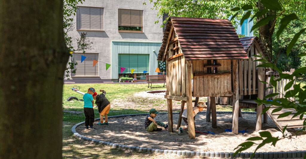 Sandspielplatz mit Holzhaus im Garten der Kita Kaulsdorf