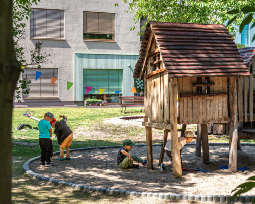 Sandspielplatz mit Holzhaus im Garten der Kita Kaulsdorf