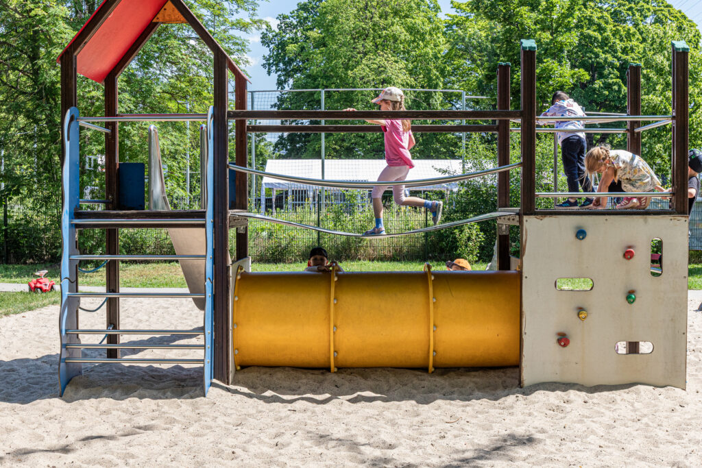 Drei Kinder spielen auf dem Klettergerüst im Garten der Kita Kaulsdorf.
