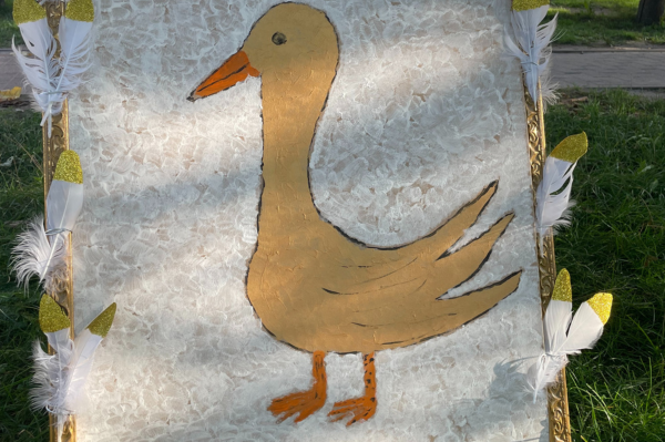 Selbst gestalteter Aufsteller zum Märchen "Goldene Gans" mit goldenen Federn