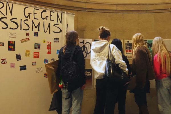 Schüler*innen betrachten Plakat-Galerie zum Thema Rassismus im Foyer der BEST-Sabel Berufsakademie